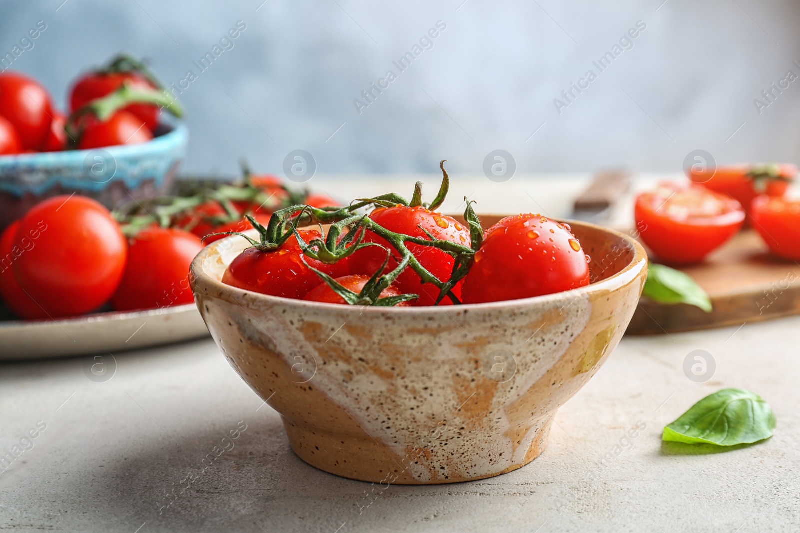 Photo of Bowl with fresh ripe red tomatoes on table