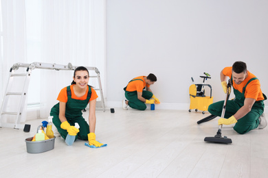 Team of professional janitors cleaning room after renovation