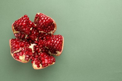 Photo of Fresh ripe pomegranate on pale green background, top view. Space for text