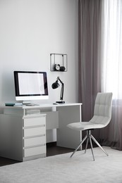 Photo of Comfortable white chair near desk in stylish office interior