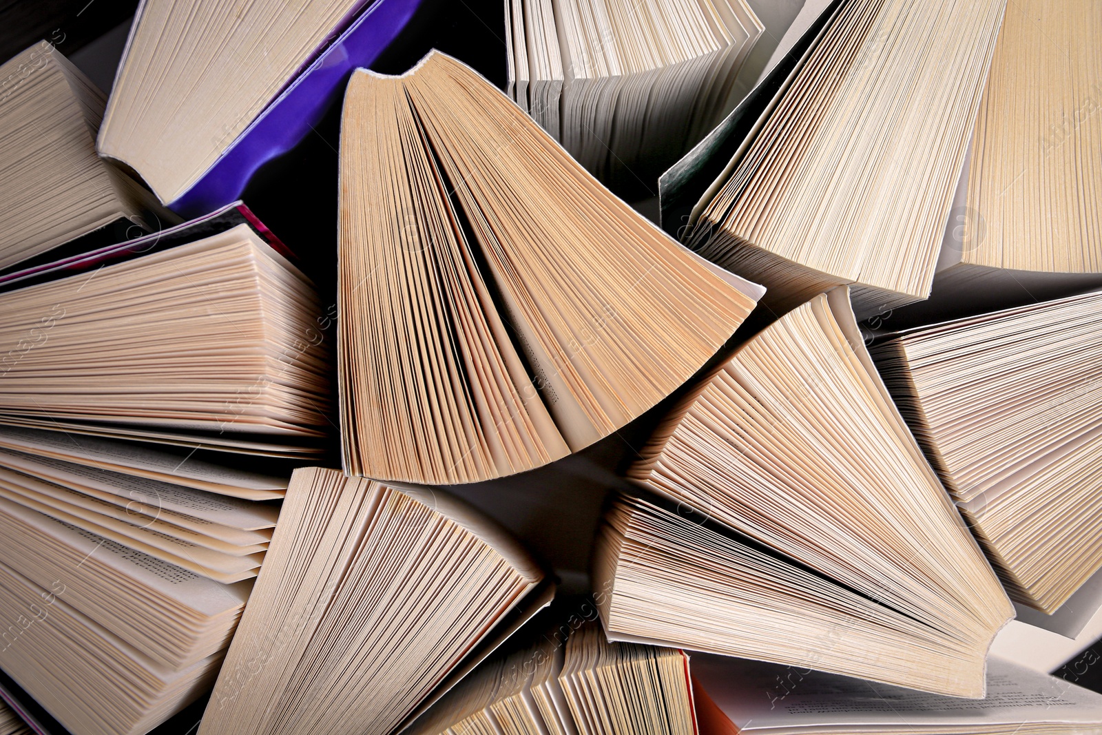 Photo of Collection of different books on white shelf, above view