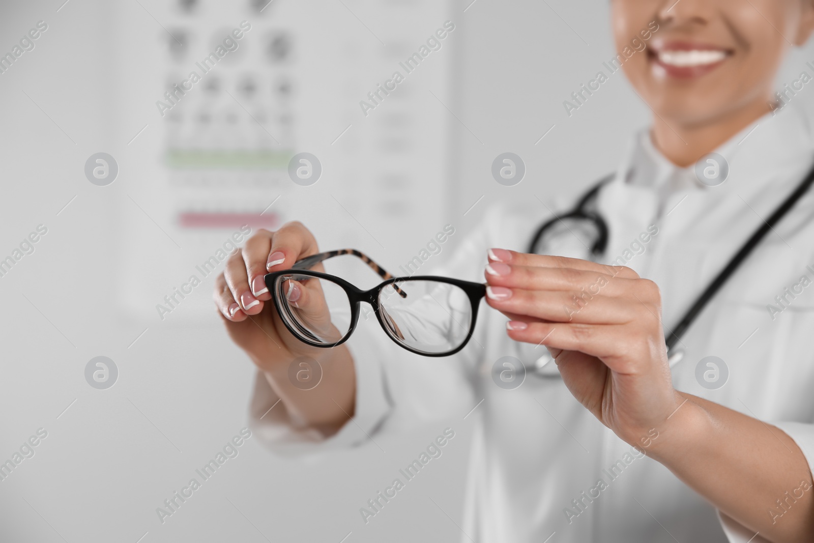 Photo of Female ophthalmologist with eyeglasses in clinic, closeup. Space for text