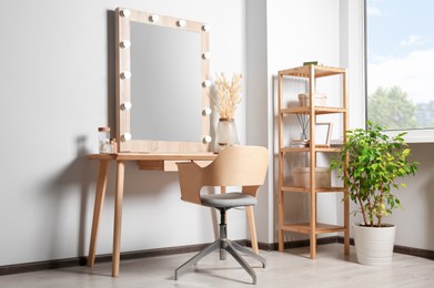 Dressing table with stylish mirror, dried reeds and other decorative elements. Interior design