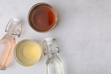 Photo of Different types of vinegar on light table, flat lay. Space for text