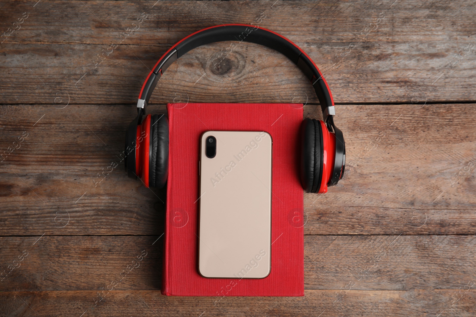 Photo of Book, modern headphones and smartphone on wooden table, top view