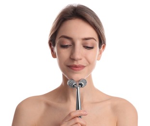 Young woman using metal face roller on white background