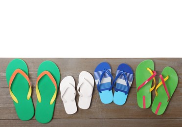 Photo of Different stylish flip flops on wooden table against white background, top view