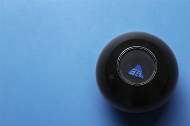Photo of Magic eight ball with prediction Answer Unclear Ask Later on blue background, top view. Space for text