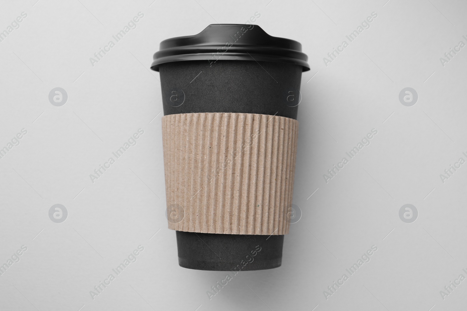 Photo of One paper cup on light grey background, top view. Coffee to go