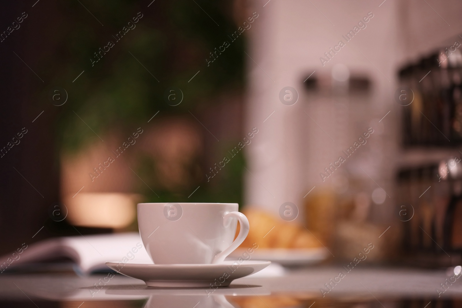 Photo of Cup of hot coffee on blurred background