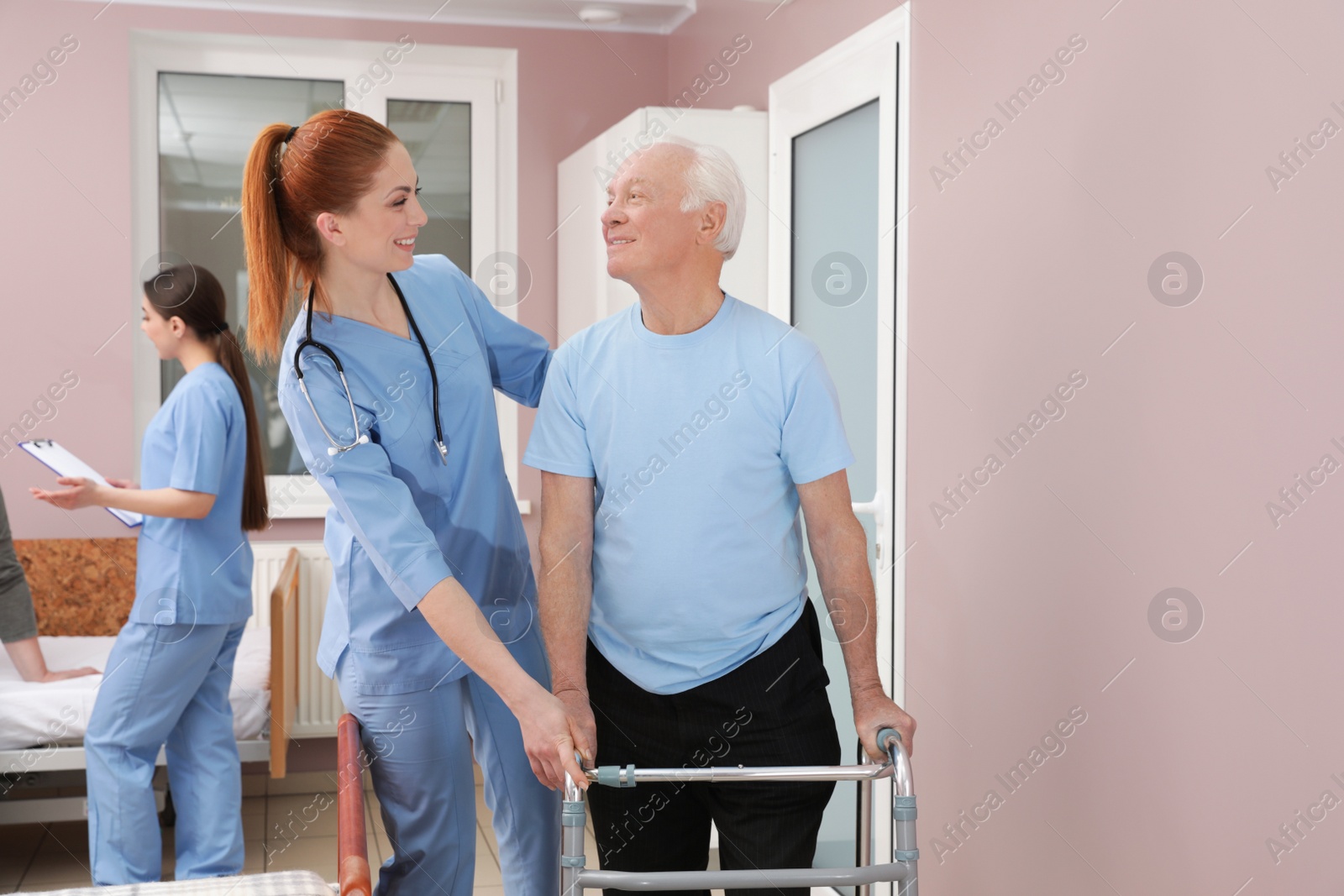 Photo of Nurse assisting senior patient with walker in hospital ward