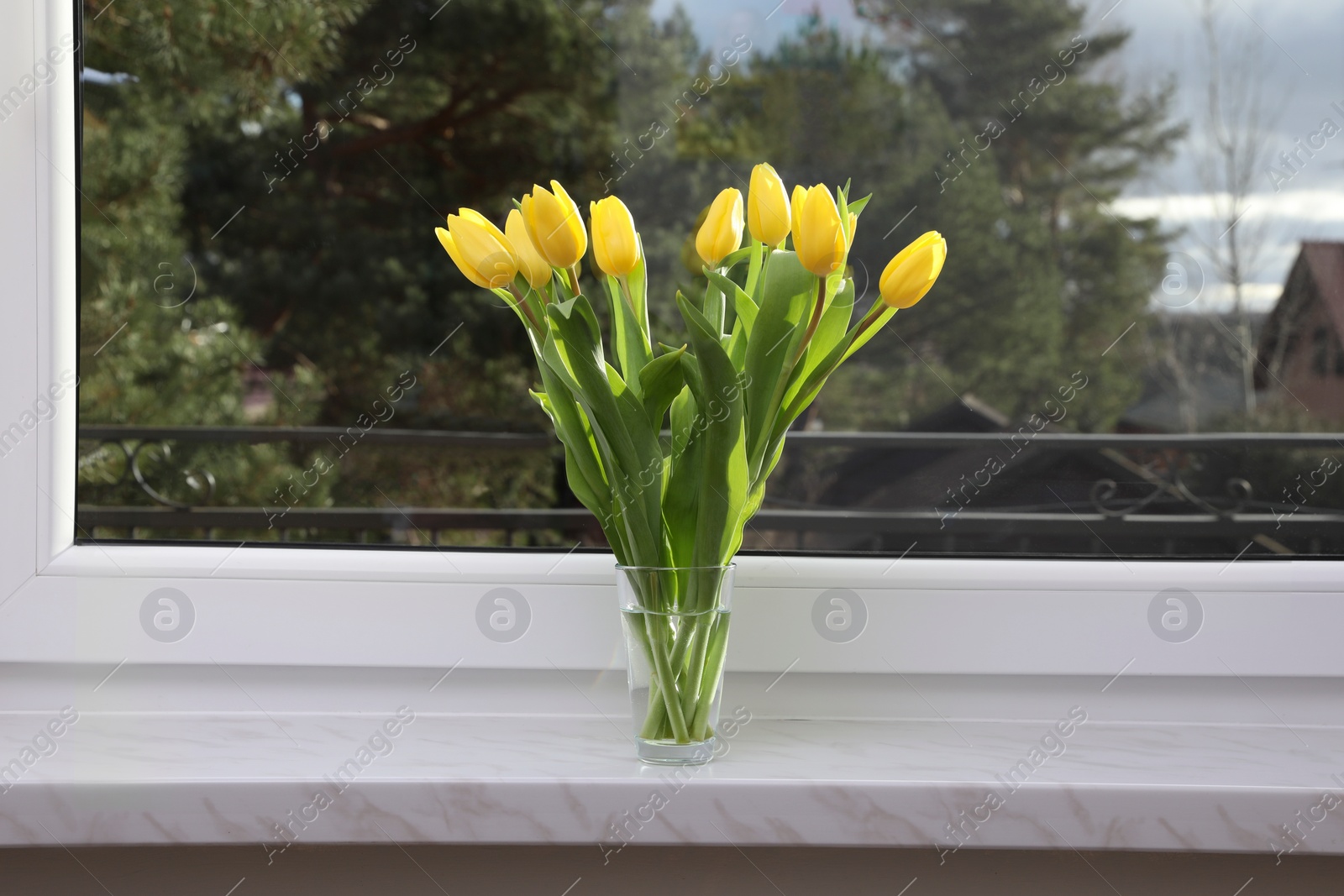 Photo of Wonderful tulips on window sill indoors. Spring atmosphere