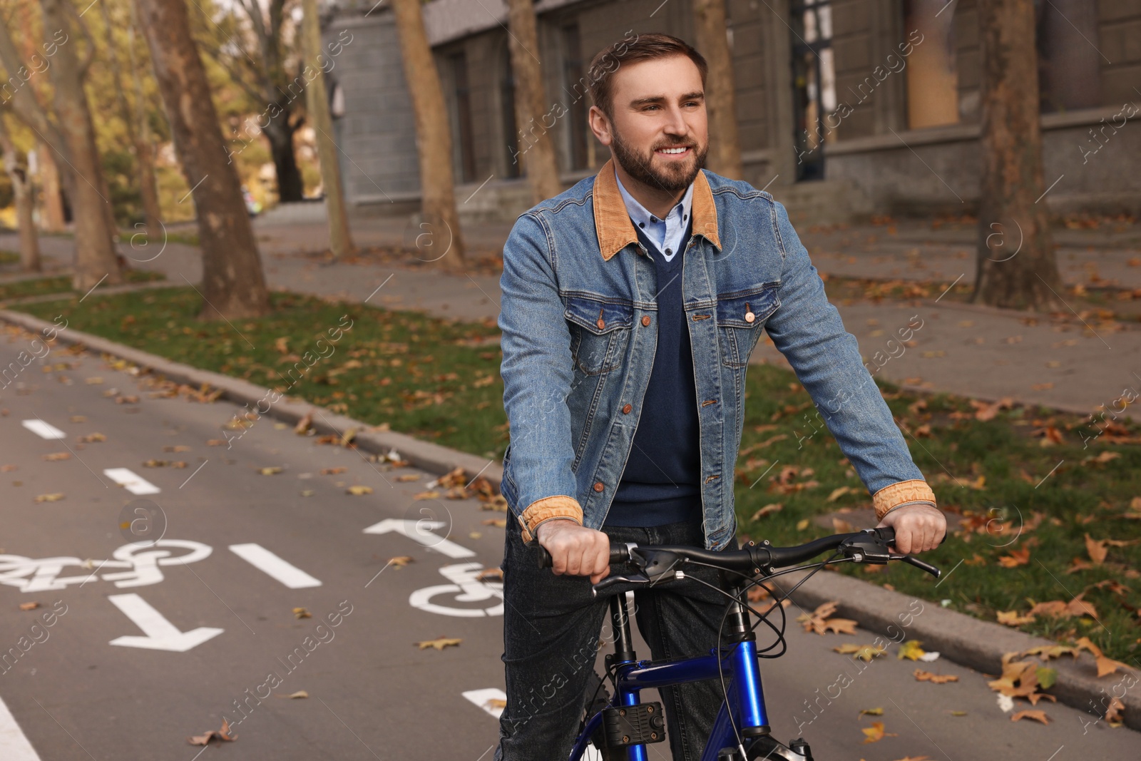 Photo of Happy handsome man riding bicycle on lane in city