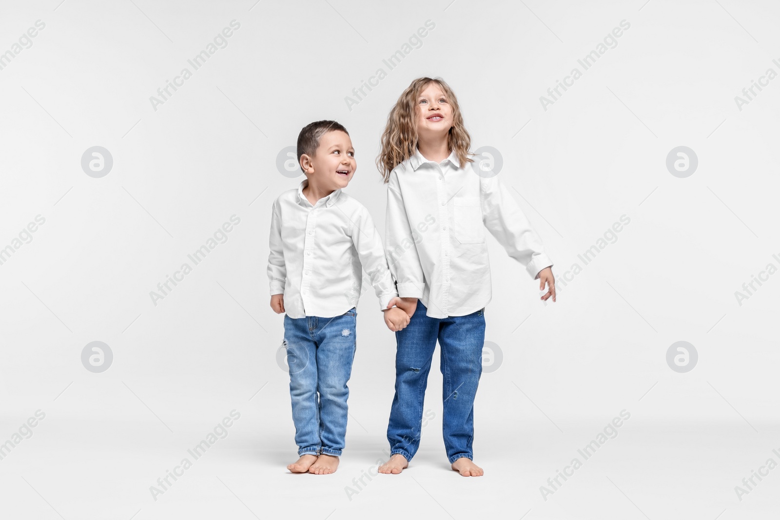 Photo of Cute little children on white background. Happy family