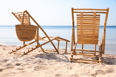 Photo of Wooden deck chairs on sandy beach near sea