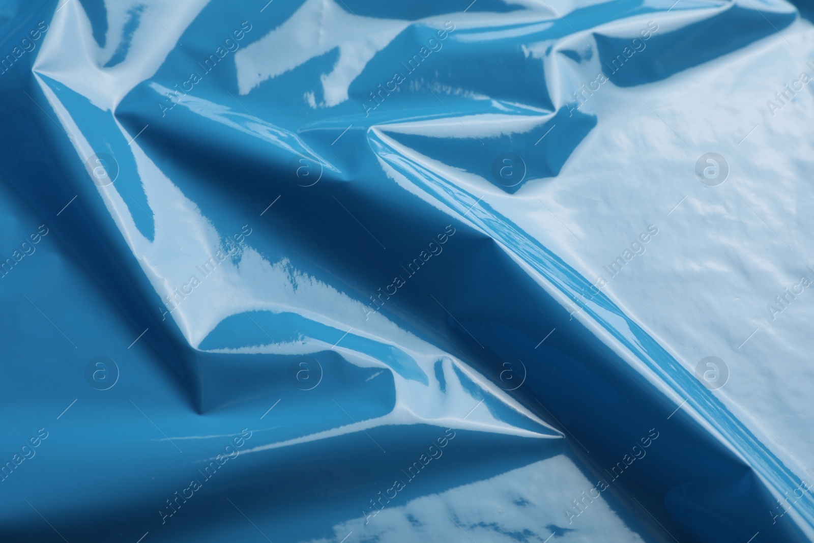 Photo of Closeup view of light blue plastic stretch wrap film as background