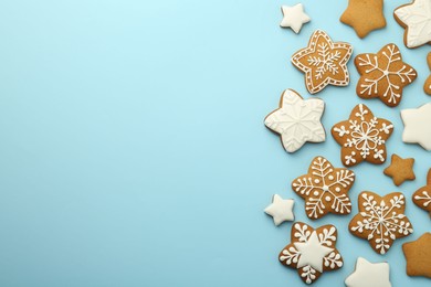 Photo of Tasty star shaped Christmas cookies with icing on light blue background, flat lay. Space for text