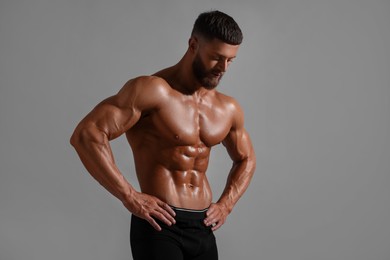 Photo of Young bodybuilder with muscular body on grey background, space for text