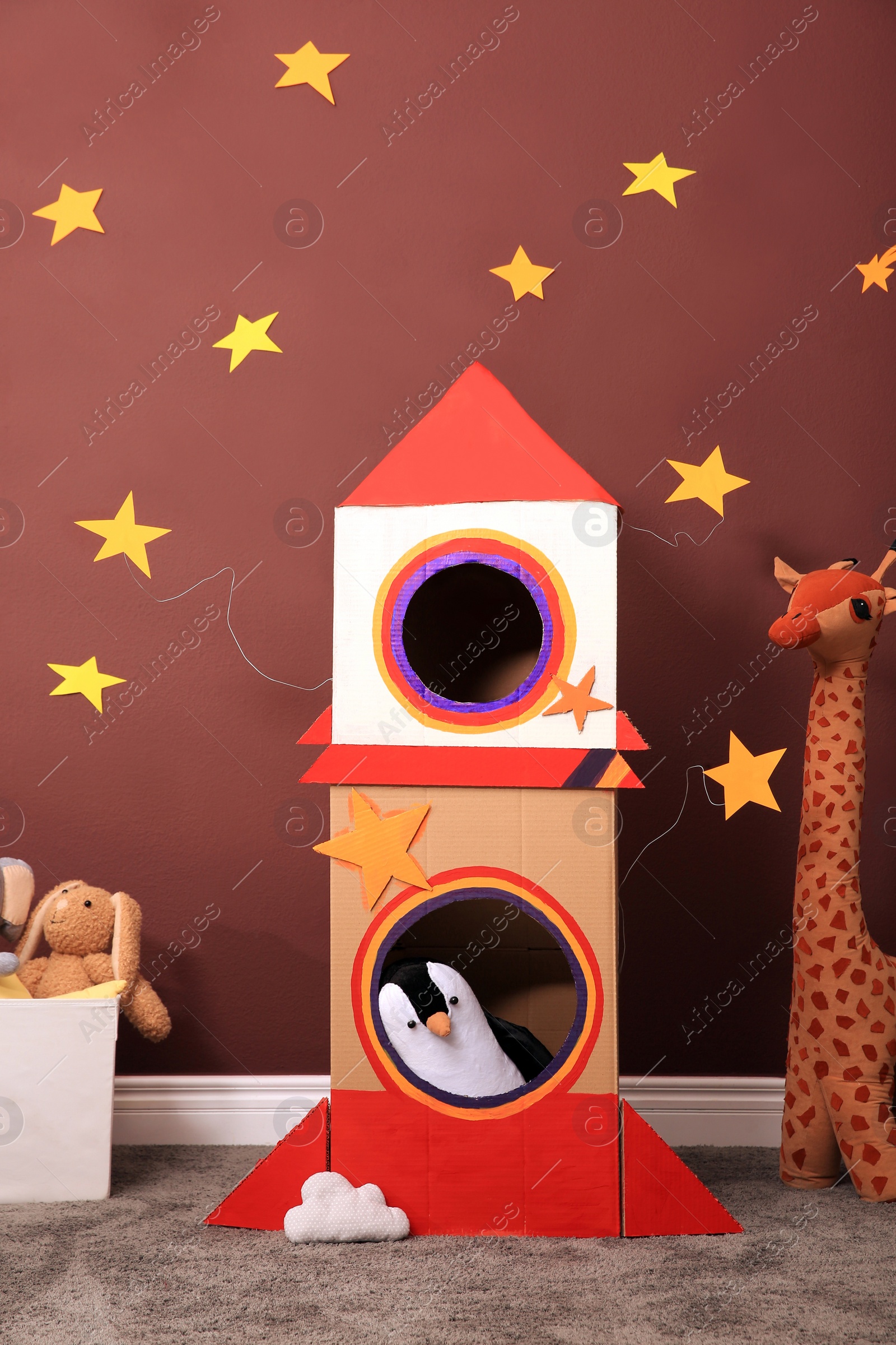 Photo of Child's room interior with cardboard rocket and toys