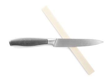 Photo of Sharpening stone and knife on white background, top view