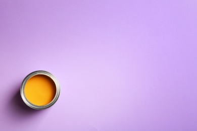 Photo of Open paint can and space for text on color background, top view