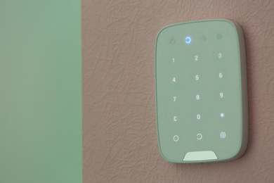 Photo of Alarm system keypad hanging on wall indoors