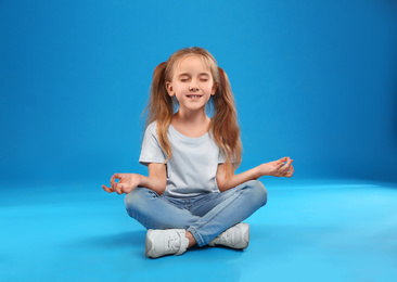 Cute little girl posing on blue background