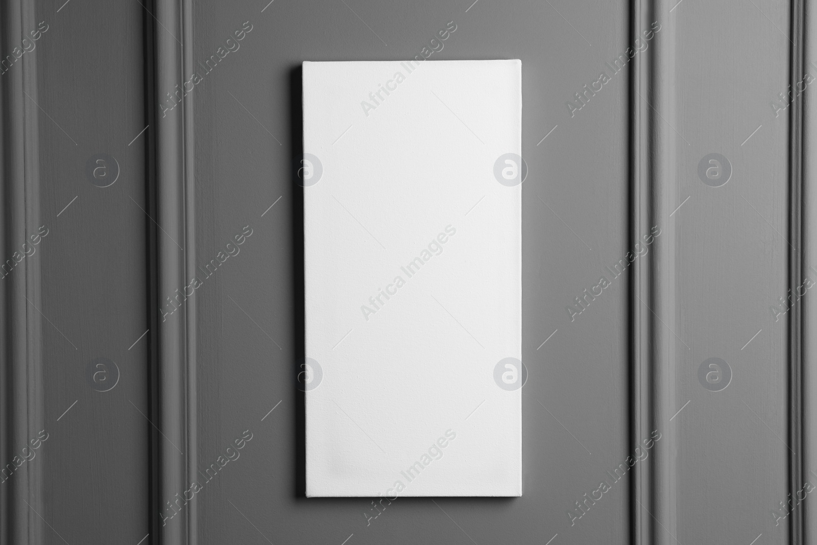 Photo of Blank canvas hanging on grey wall, space for text