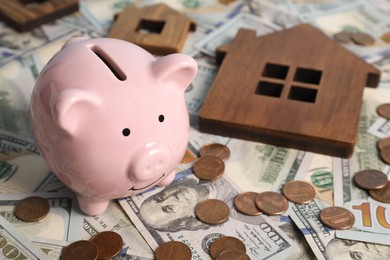 Photo of Piggy bank, house model on money, closeup. Space for text