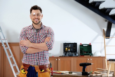 Photo of Handsome working man indoors, space for text. Home repair