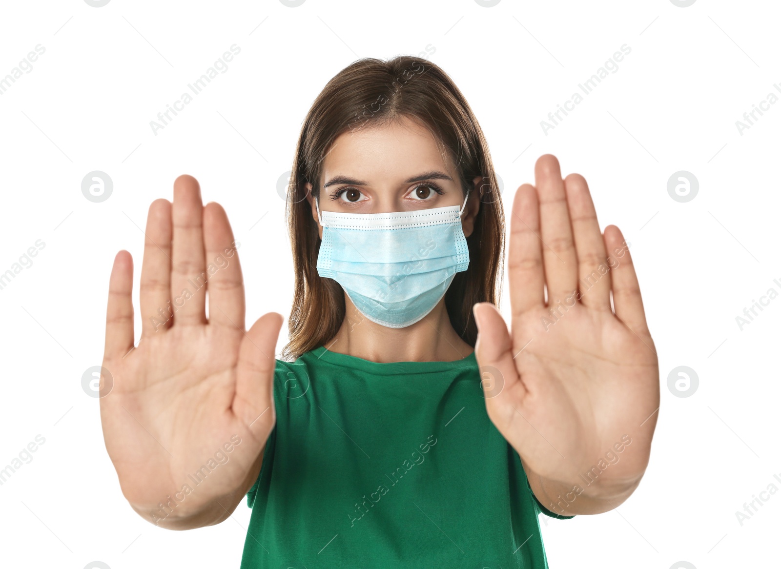 Photo of Woman in protective mask showing stop gesture on white background. Prevent spreading of coronavirus