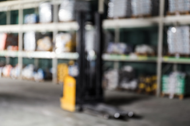 Photo of Blurred view of modern electric pallet truck in wholesale warehouse
