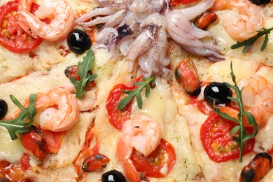 Photo of Tasty fresh pizza with seafood as background, closeup