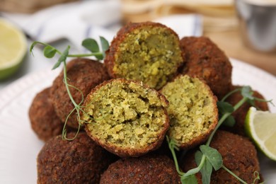 Delicious falafel balls and microgreens on plate, closeup