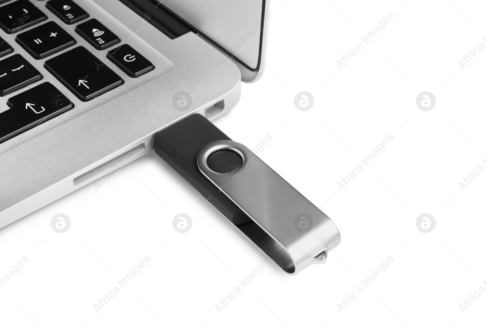 Photo of Modern usb flash drive attached into laptop on white background, closeup