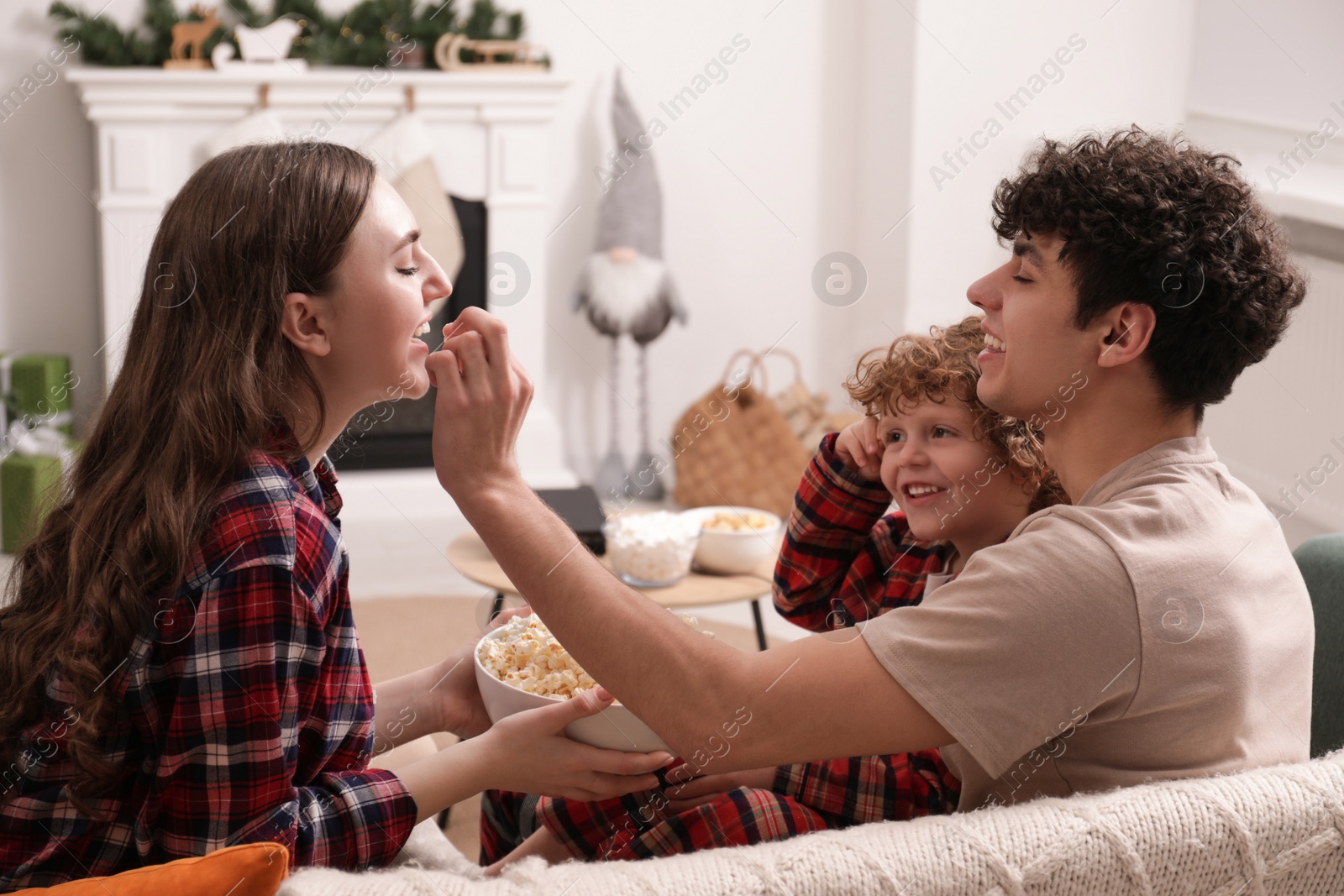 Photo of Family with popcorn spending time together at home. Watching movie via video projector