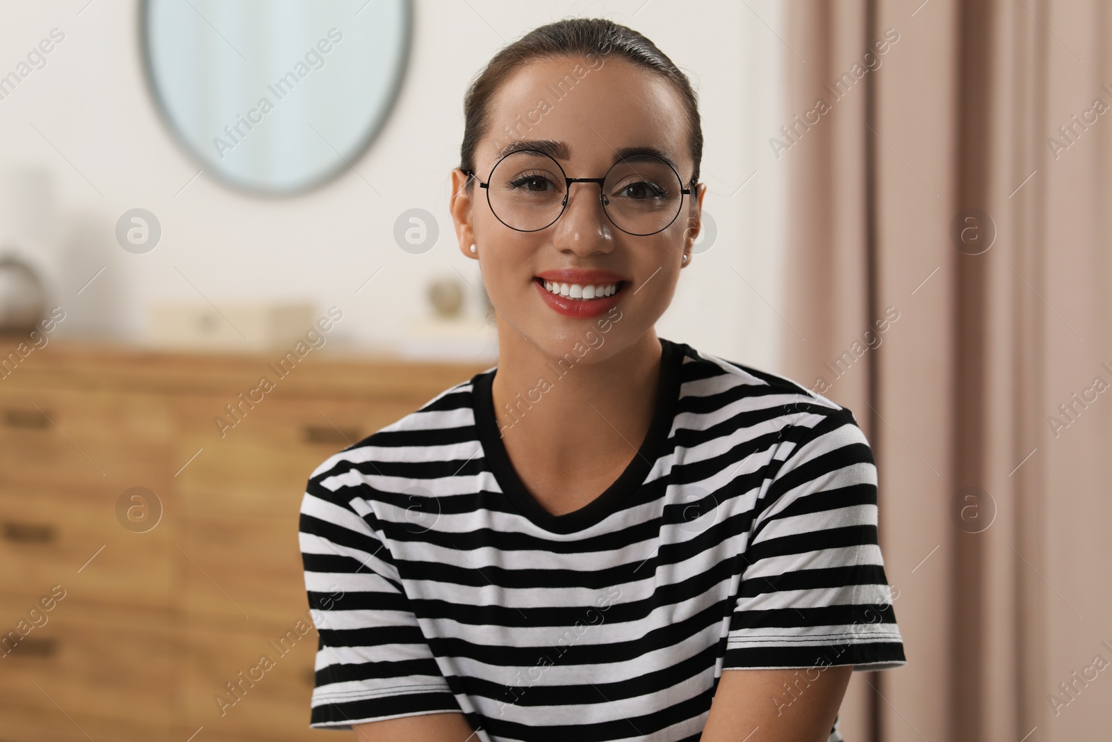 Photo of Portrait of beautiful young woman with glasses indoors. Attractive lady smiling and looking into camera