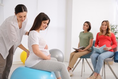 Photo of Group of pregnant women with midwife at courses for expectant mothers indoors