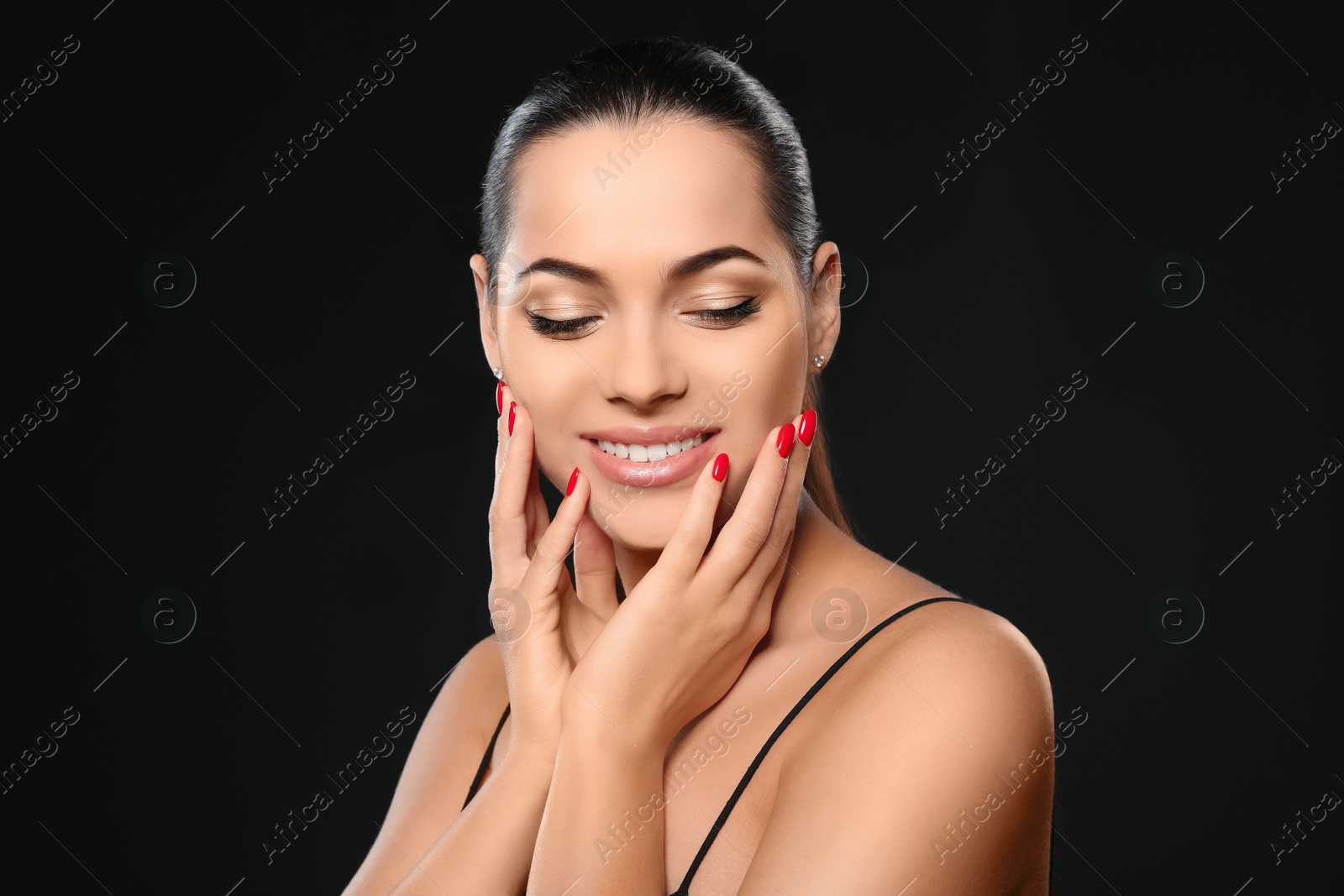 Photo of Portrait of beautiful young woman with bright manicure on black background. Nail polish trends