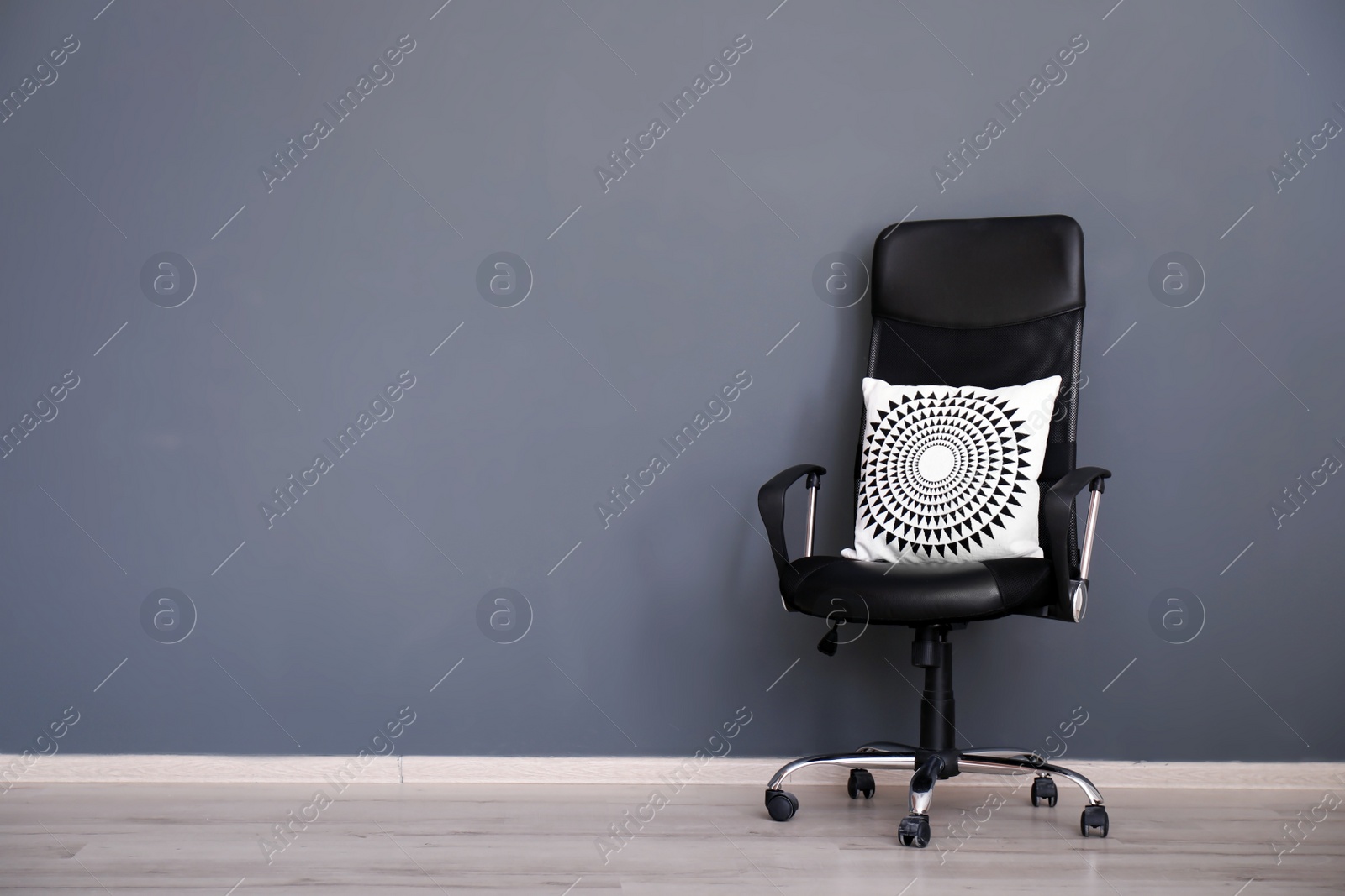 Photo of Leather armchair with soft pillow near grey wall