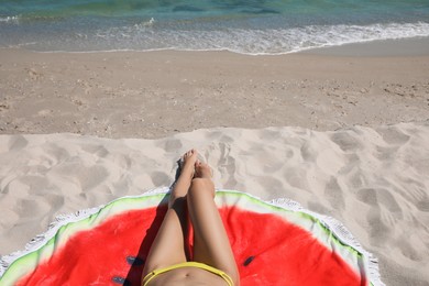 Woman with beach towel on sand near sea, closeup