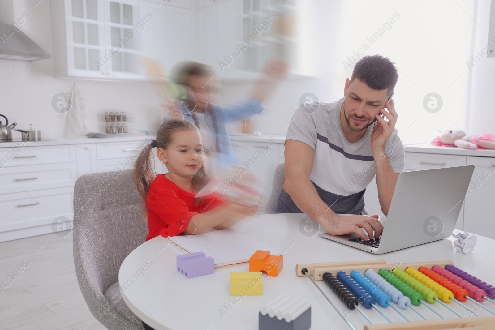 Image of Children disturbing overwhelmed man in kitchen. Working from home during quarantine