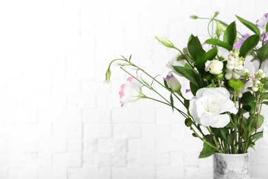 Photo of Vase with bouquet of beautiful flowers on blurred background. Space for text