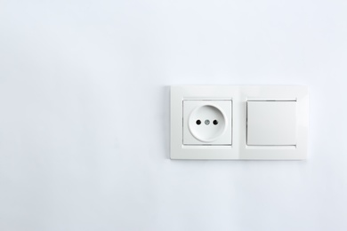 Photo of Light switch and power socket on white background. Electrician's equipment