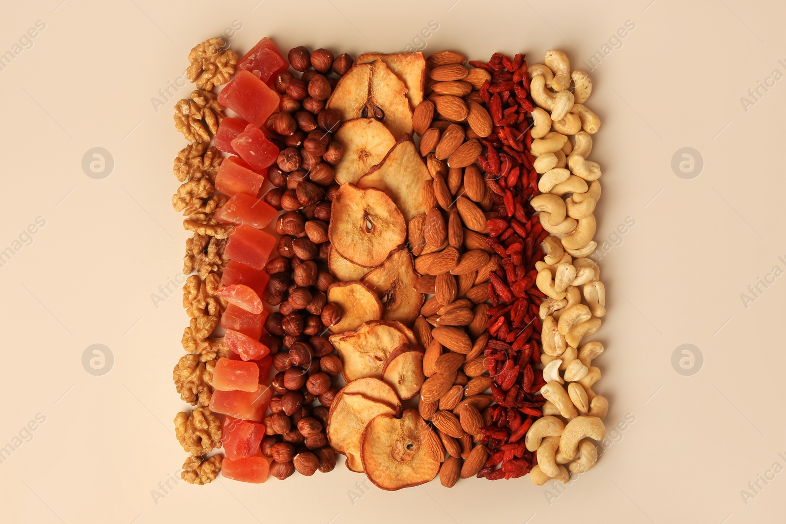 Photo of Mix of delicious dried nuts and fruits on beige background, flat lay