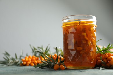 Delicious sea buckthorn jam and fresh berries on wooden table. Space for text