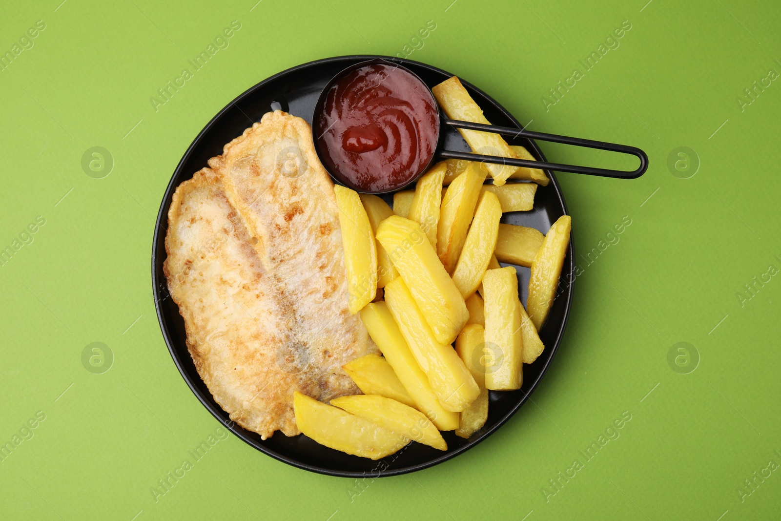 Photo of Delicious fish and chips with ketchup on green table, top view