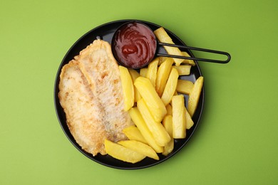 Photo of Delicious fish and chips with ketchup on green table, top view