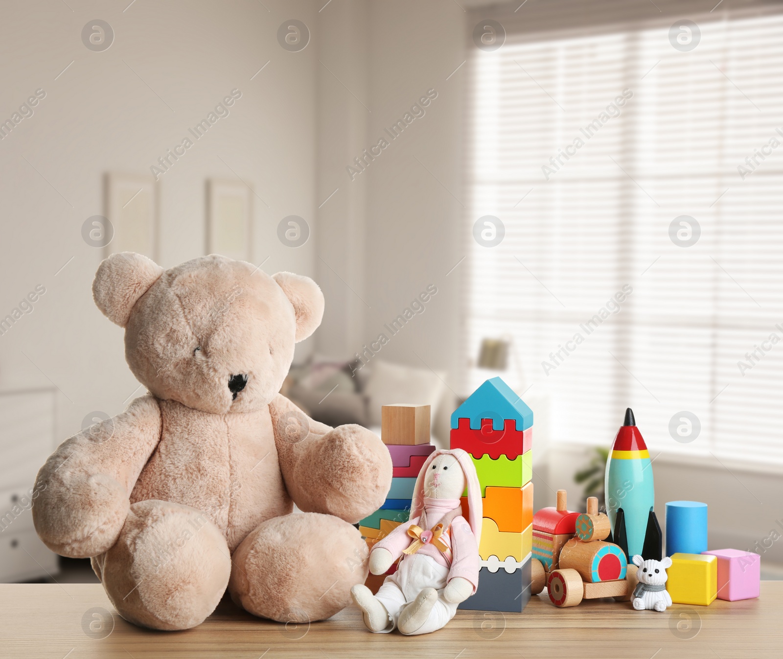 Image of Set of different cute toys on wooden table in children's room