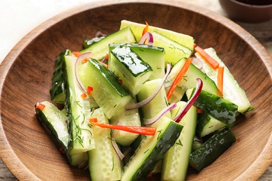 Photo of Delicious cucumber salad with onion and pepper on plate, closeup